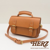 職人手作皮革雙扣兩用迷你肩背包，採用天然棕色皮革，附有金屬釦環和可調式肩帶，設計簡約。