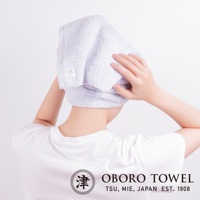 淡紫色毛巾擦髮巾，材質柔軟，質地輕盈，包裹於頭部，展示五倍吸水抗臭功能。