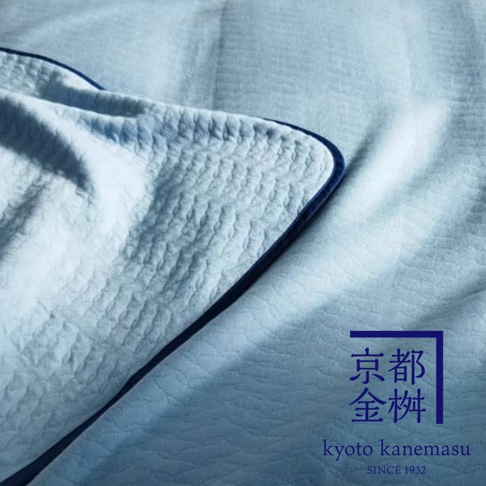 淺藍色天絲棉絎縫單人毯，質感柔軟，細緻紋理，搭配深藍色滾邊。