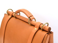 職人手作皮革屋瓦風兩用側背包 (CW-147) M，採用天然皮革材質，呈現溫潤的焦糖棕色。包款設計有堅固的皮革提把，搭配黃銅金屬環扣，展現復古質感。