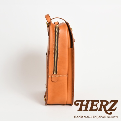 職人手作皮革商務休閒兩用後背包 R-36，展示側邊，採用棕褐色皮革，配有黃銅色拉鍊和縫線細節。