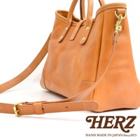 職人手作皮革托特包，天然棕色，附可調式肩帶，金色金屬扣件，簡約設計，適合日常使用。