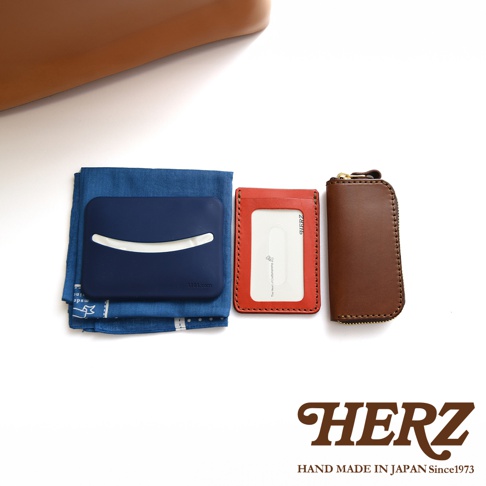 模式B： 日本HERZ手工皮革證件夾和鑰匙包，旁邊放著深藍色布料和藍色卡套。