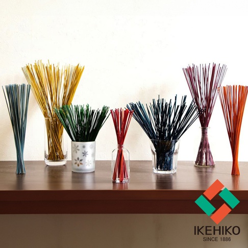 一排七束不同顏色的天然藺草清淨棒，包含深藍、金黃、翠綠、鮮紅、深藍、紫紅色及橘紅色，部分插於玻璃瓶中，部分為白色帶有雪花圖案的陶瓷容器，整體呈扇形散開。