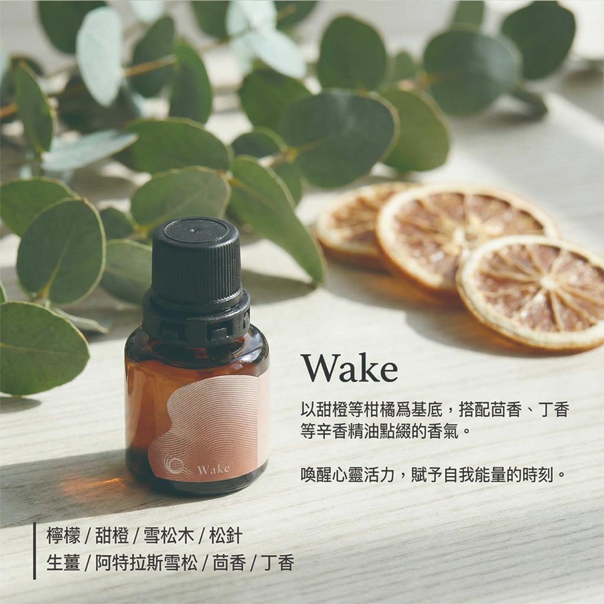 模式B： 一瓶琥珀色精油瓶，瓶身上有曲線圖案和Wake字樣，瓶蓋為黑色，背景是銀葉桉樹葉和三片乾燥檸檬片，右側文字為Wake，以及介紹香氣與使用情境的中文說明，下方則列出香氛成分。