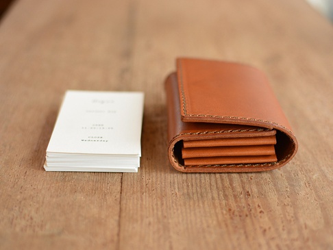 職人手作寬版皮革Organ證件分類收納夾，顏色為棕褐色，材質為皮革，展示了其層疊式收納設計，旁邊放有一疊白色卡片。