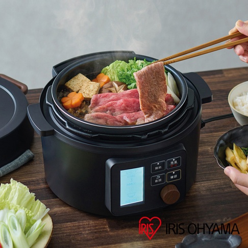 黑色電子壓力鍋，內有壽喜燒食材，包括牛肉片、豆腐、紅蘿蔔和蔬菜。鍋體帶有數位顯示螢幕和旋鈕。