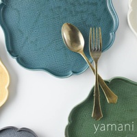 青藍色、綠色、黃色及灰色美濃燒花型主食盤，表面帶有細膩紋理，盤中擺放金色湯匙與叉子。