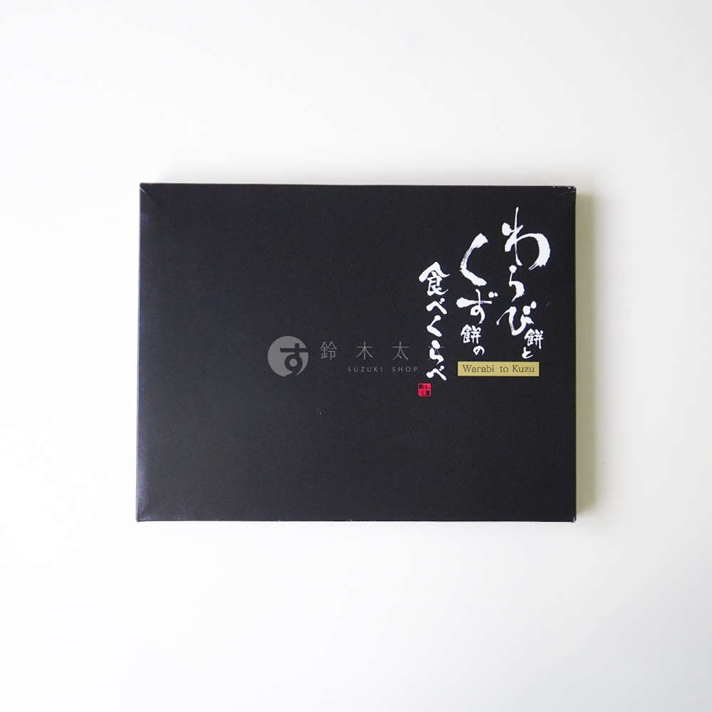 一個長方形的黑色伴手禮盒，封面中央印有白色毛筆字體寫著わらび餅とくず餅，下方配有英文翻譯及鈴木商店的商標與名稱，整體設計風格簡約典雅。
