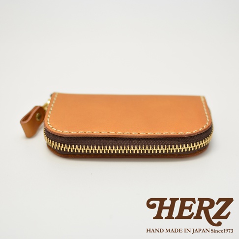 HERZ 鑰匙包，簡約橢圓形設計，咖啡色皮革搭配金色拉鍊，手工製作於日本。