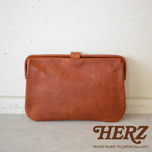 職人手作皮革Organ手拿包 G-38，咖啡色，簡潔設計，搭配金屬扣環，整體呈現自然的皮革紋理。