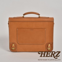 職人手作淺棕色皮革歐風三用學生包，帶有精緻縫線、金屬扣環和頂部提把，正面有品牌壓紋和置物袋。