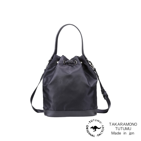 TUTUMU 黑色皮革底部抽繩水桶包，配有手柄和斜挎肩帶，下方印有 TAKARAMONO TUTUMU Made in jpn 的圓形品牌標誌。