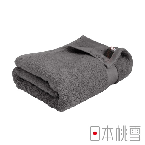 一條折疊的灰色今治匹馬棉浴巾，材質柔軟，帶有品牌標籤。
