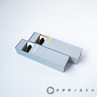 兩個淺灰色紙盒試管瓶放置架，盒蓋上分別有銀色和金色圓點裝飾，盒內露出木質底座，可放置試管。