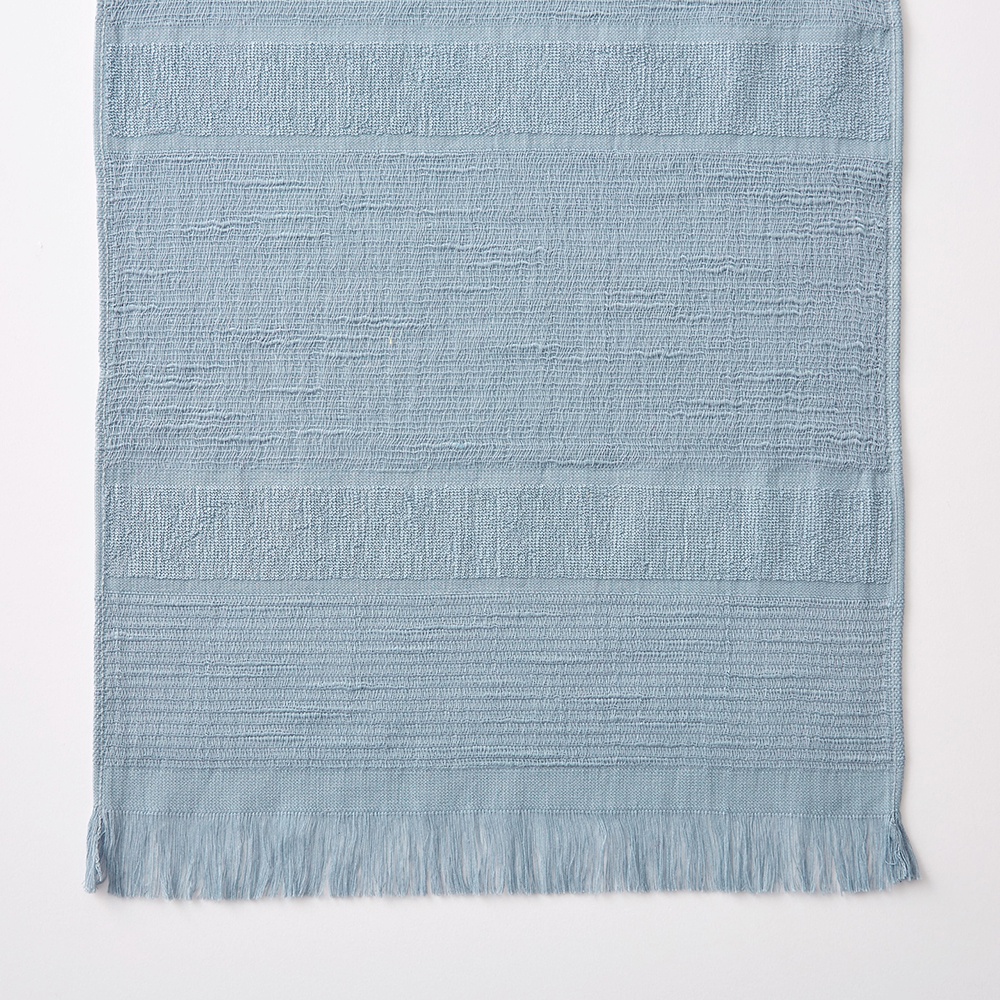 淺藍色今治匹馬棉圍巾，織有粗細交錯的橫條紋紋理，一端帶有流蘇。