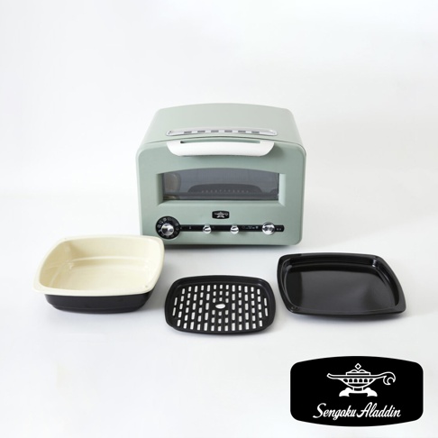 淺綠色復古多用途烤箱，配有奶油色內盤、黑色烤網和黑色烤盤，附有銀色把手和控制旋鈕。