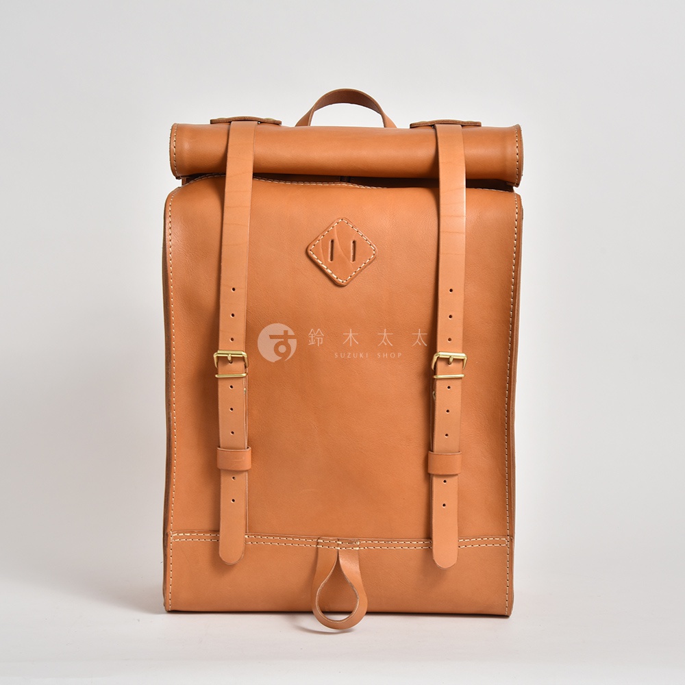 職人手作皮革露營登山用大容量後背包 R-19，原色皮革，捲口設計，附有兩條可調節長度的皮革背帶，配有黃銅色扣環，正面中央有菱形皮革飾片，底部有皮革提環。