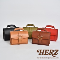 五款職人手作皮革迷你單肩包，包括黑色、淺棕色、軍綠色、棕色和紅色。每款包皆為皮革材質，配有提把、掀蓋和金屬釦具，設計簡約經典。