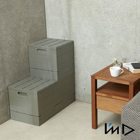 灰色塑膠格子磚可堆疊摺疊收納椅，兩張堆疊成階梯狀，頂部和側面有提把，表面有網格紋理。