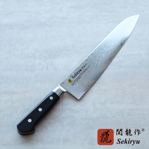 VG10不鏽鋼33層大馬士革紋路牛刀，刀刃閃耀，具備黑色三鉚釘手柄，整體為銀色與黑色。