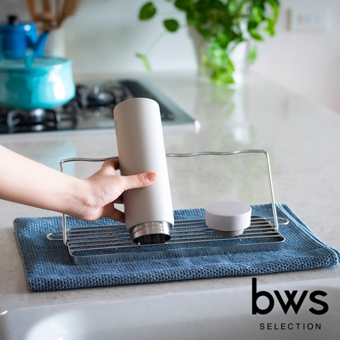 不鏽鋼折疊杯壺瀝水架，附有灰色保溫瓶與白色瓶蓋，置於藍色吸水墊上。