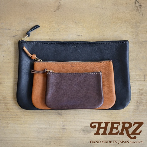 職人手作皮革Organ拉鍊式小物收納袋，三種尺寸疊放，分別為黑色、棕褐色及深棕色皮革，皆配有金色拉鍊及皮革拉頭，縫線清晰。