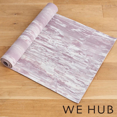 WE HUB 品牌標誌在鋪展的紫色大理石紋瑜珈墊下方。