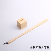 加長檜木鞋拔，附一個同材質的方形鞋拔座，鞋拔末端有黑色掛繩。
