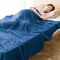 CUMUCO 四層紗輕暖舒柔四季毯，展示深藍色，覆蓋在床上，一名女子在其下休息。