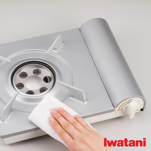 銀色節能高效瓦斯爐，爐面設有十字支架，中央為圓形爐頭，配有白色清潔抹布，爐具右側有白色旋鈕開關，標示ON和OFF。