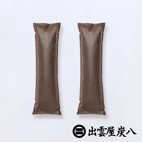 兩包深棕色的長條形出雲屋炭八除濕袋並排擺放，外袋採用雙層不織布材質，表面印有品牌標誌與文字，整體設計簡約實用，下方印有出雲屋炭八的品牌名稱與標誌。