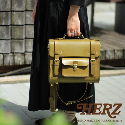 職人手作皮革學院風三用迷你後背包，橄欖綠色，採用厚實皮革製作，設計有翻蓋前袋、束帶及金屬扣環，可手提或肩背。