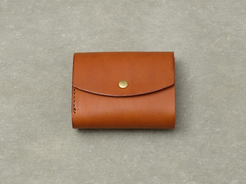 職人手作皮革Organ迷你短夾，採用溫潤的棕色皮革製成，設有金屬按扣，設計簡潔實用。