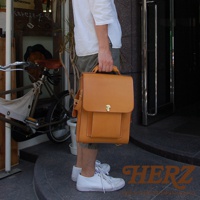 職人手作皮革復古後背包，黃褐色，配有金色鎖扣和縫線細節，由皮革製成。