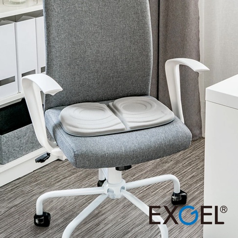 THE OWL HighestCompact 貓頭鷹進階款隨身坐墊，淺灰色，柔軟材質，兩側有圓形凹槽設計，放置於灰色布面辦公椅上。