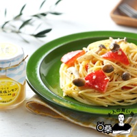 一盤義大利麵，麵條呈淡黃色，配有切塊的番茄、蘑菇和醬汁。旁邊是一個標有「熟成藻鹽漬檸檬」的玻璃罐，罐身上有藍白相間的波浪紋和太陽圖案。