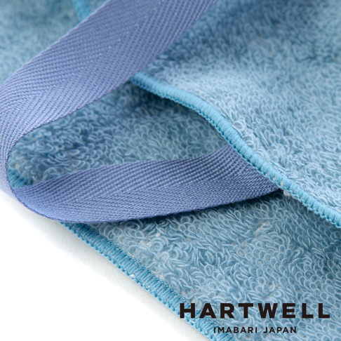 淺藍色毛巾布材質的牙刷收納袋，有深藍色織帶，白色背景。