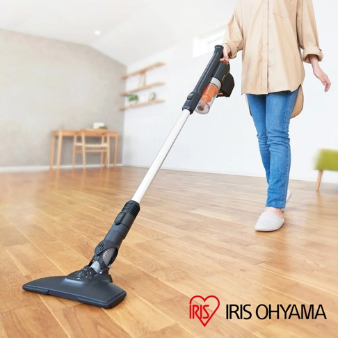 氣旋式超輕量無線手持吸塵器 SCD-140，主體為黑色和銀白色，配有透明集塵筒，顯示部分灰塵。吸頭為黑色，與木質地板接觸。