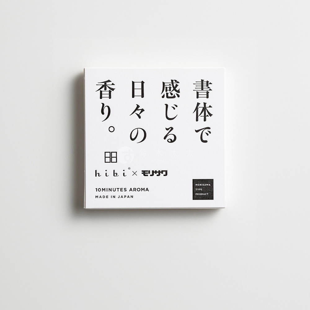 方形的白色紙盒包裝，上方印有日文字體，並標示 hibi 與 Morisawa 的聯名標誌，盒裝左下方標註為日本製造的十分鐘香氛產品，整體設計呈現簡約風格。