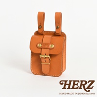 職人手作皮革經典腰袋，採用天然皮革材質，呈現溫潤的棕褐色。方形設計，正面有翻蓋與皮帶束口，搭配金屬釦環，兩側有掛環可固定於腰帶，整體工藝精緻。