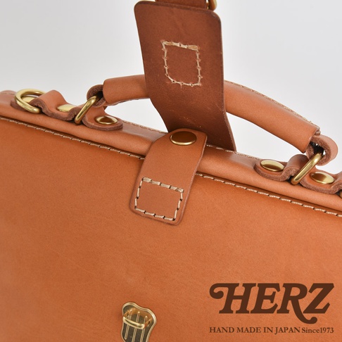 職人手作皮革迷你軟皮杜勒斯包，以自然色澤的皮革製成，配有黃銅色金屬扣和五金配件，展現經典質感。