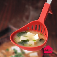 紅色的 UCHICOOK 濾水湯匙，湯匙頭有長條狀的濾水孔，盛有日式味噌湯，湯內有豆腐塊、海帶和蔥花。