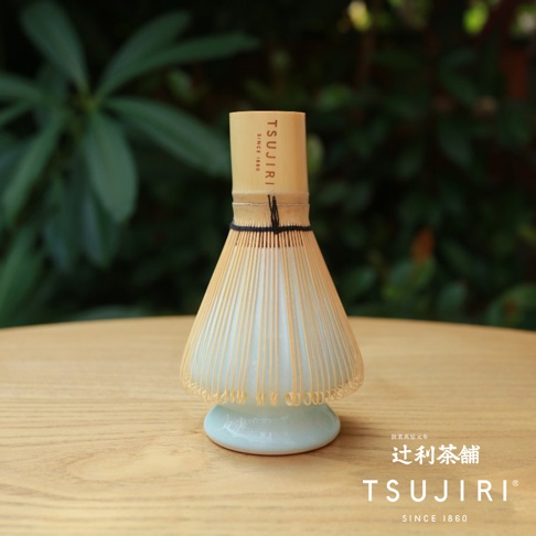 竹製抹茶茶刷，帶有淺藍色陶瓷底座，頂部有品牌標誌。