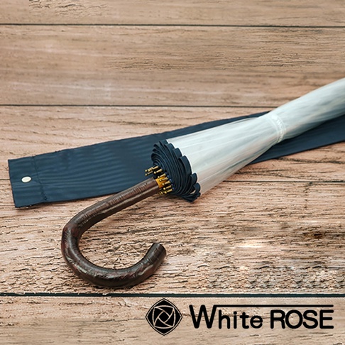 職人高級樺木透明傘，傘面為透明材質，傘柄為彎曲的深棕色樺木，傘骨為黑色，搭配深藍色傘套，整體風格簡潔優雅。