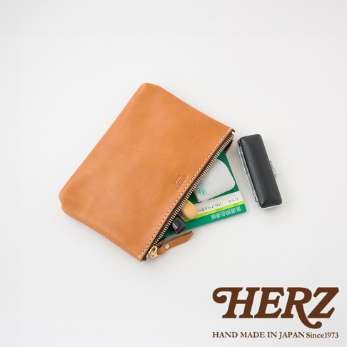 駝色皮革長方形拉鍊收納包，內有綠色文件和黑色印章，拉鍊為銀色，包身有品牌壓印。