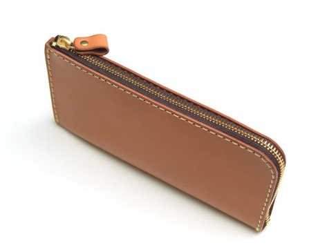 淺棕色皮革L型拉鍊長夾，設有金色拉鍊及同色系皮革拉頭，邊緣以米白色車線縫合。