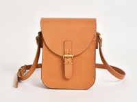 職人手作皮革翻蓋迷你單肩包，採用天然棕色皮革製成，設有黃銅色搭扣和可調節肩帶，風格簡約。