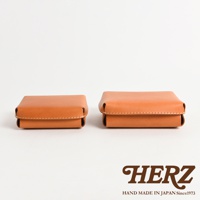 兩個 tan 色的皮革收納盒，一個較小，一個較大，皆以手工縫線製作，呈方形，蓋子向上翻折，展示其簡潔的設計。