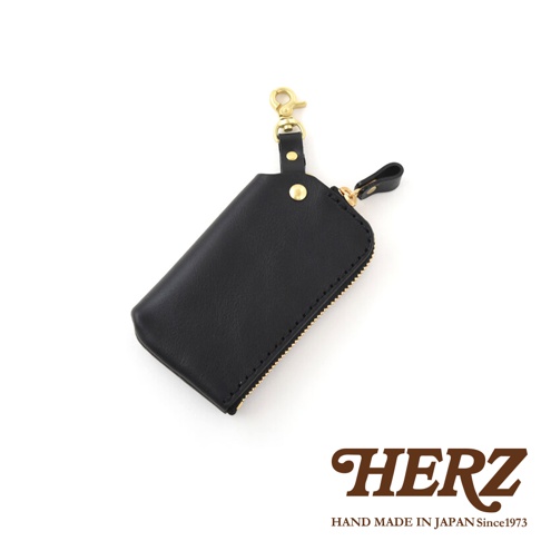 黑色皮革鑰匙包，配有黃銅鉤環和拉鍊，簡約設計，適合日常攜帶。